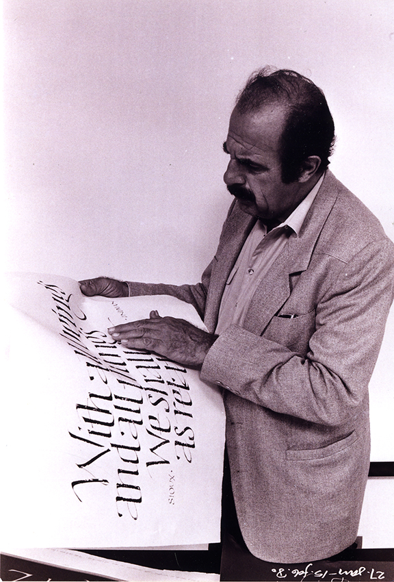Ed Benguiat looking at sheet of hand lettered words